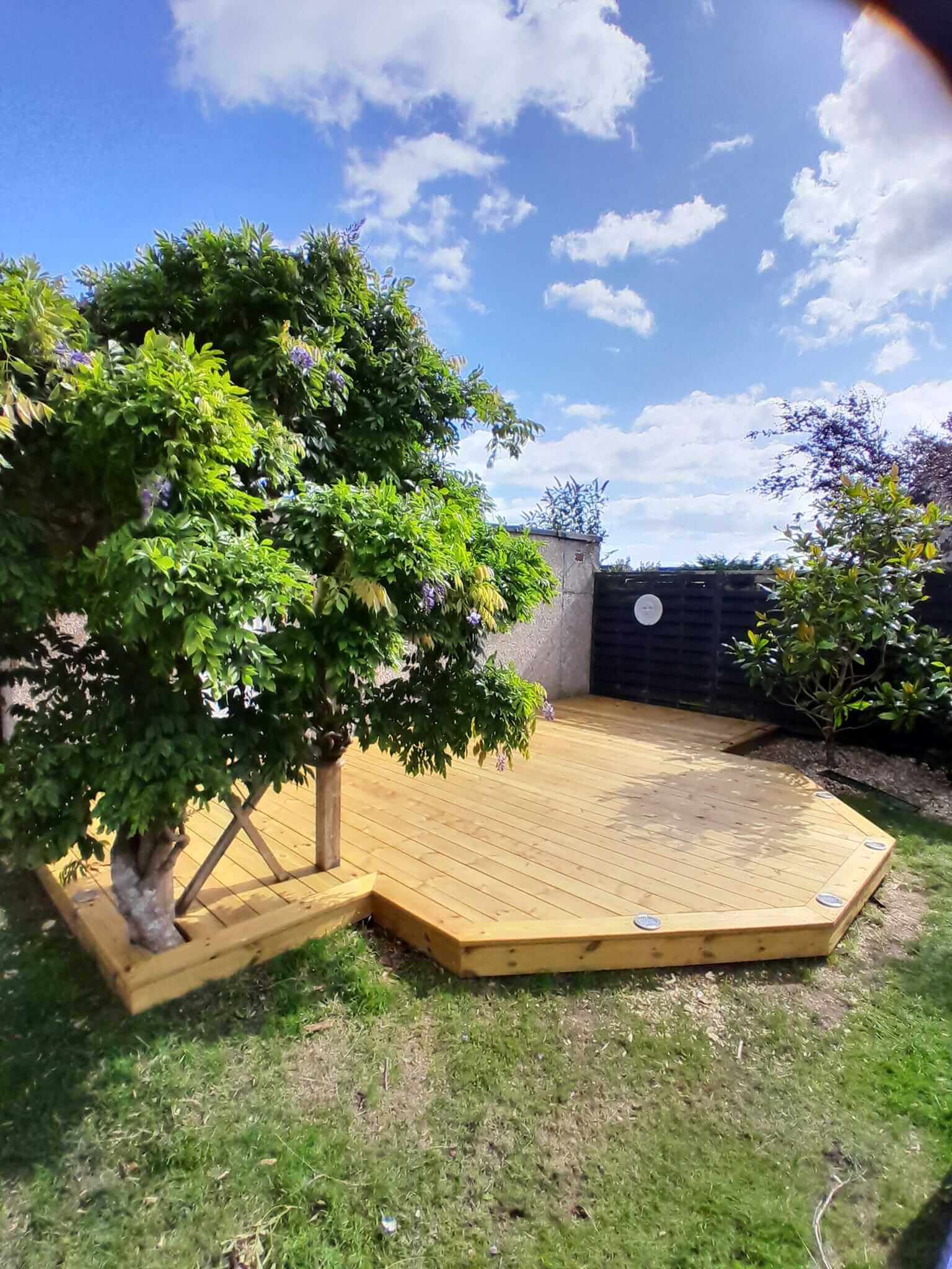 Bespoke octagonal timber garden decking with integrated tree surround and recessed deck lights