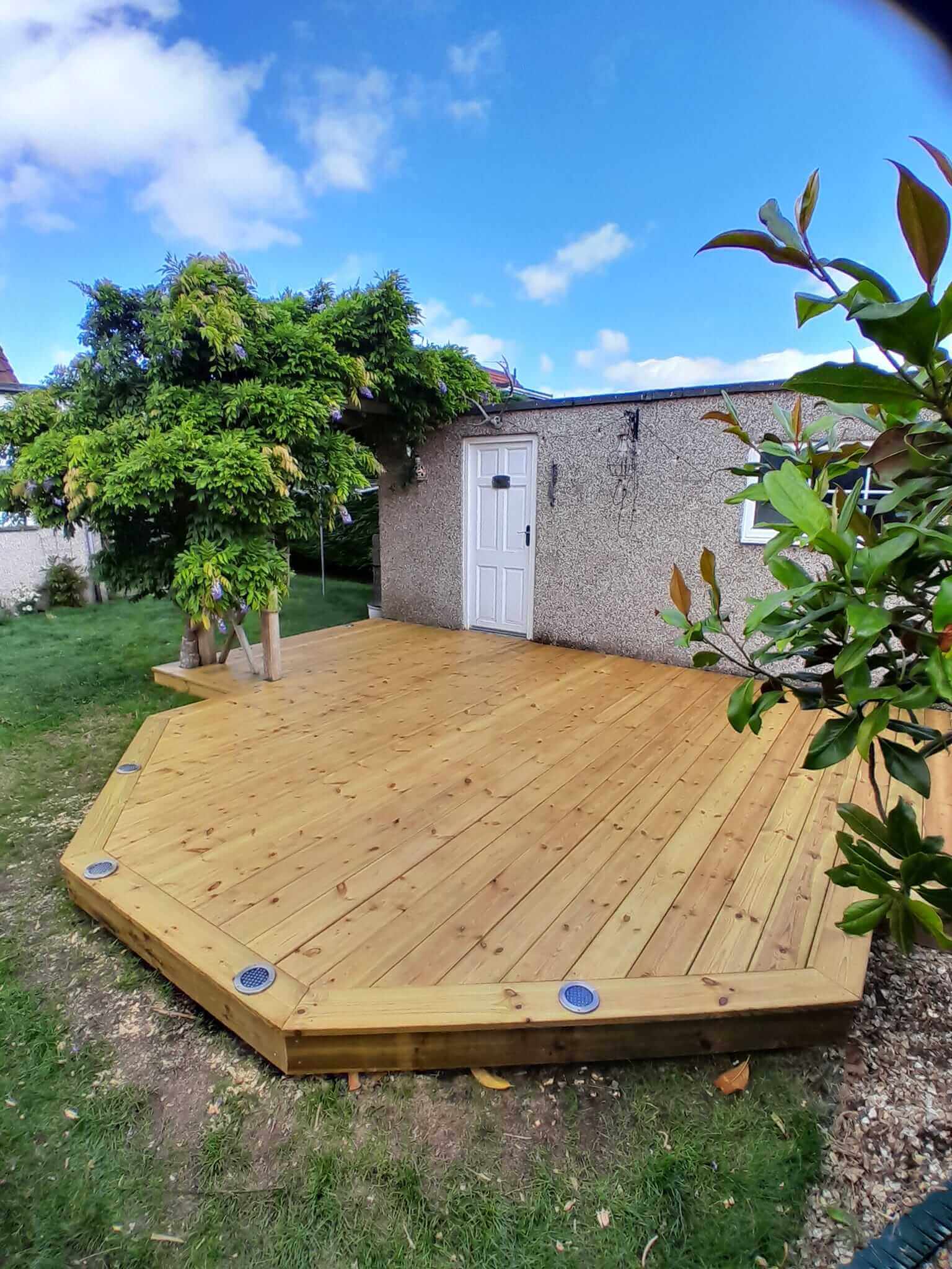 Bespoke octagonal timber garden decking with integrated tree surround and recessed deck lights