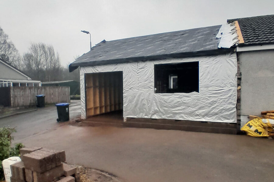 Bankfoot residential extension under construction, slate roof and breather membrane applied to timber frame walls, large glazed opening to front, suburban setting