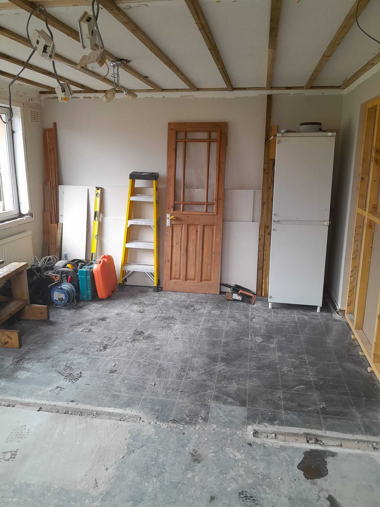 Room at mid-construction stage, walls and floor cleared for open-plan kitchen conversion