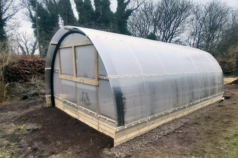 Completed Poly Crub polycarbonate growing tunnel with timber base frame, window openings and custom stable door, Alyth garden setting